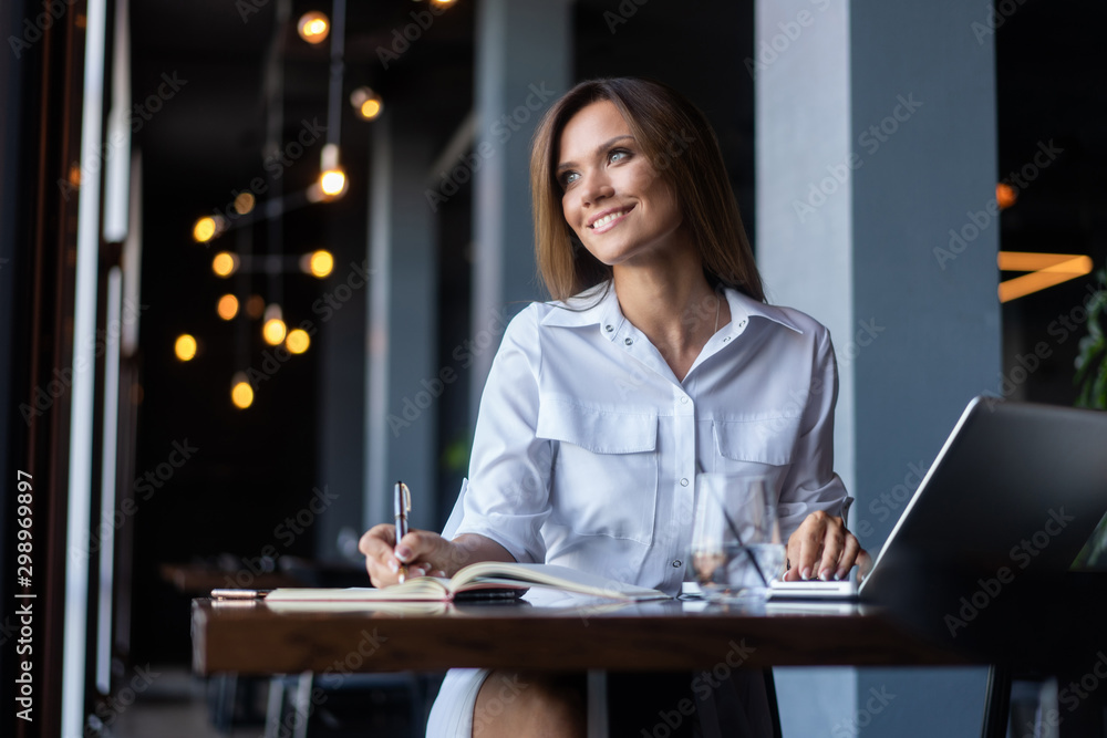 Brunette Business woman working with papers near window in cafe Brunette Business woman working with papers near window in cafe