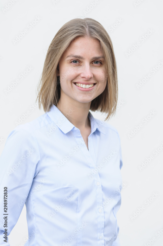 Blonde bussiness woman dressed casual with a perfect smile, standing near a white wall Blonde bussiness woman dressed casual with a perfect smile, standing near a white wall