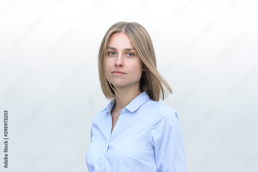 Blonde bussiness woman dressed casual with a perfect smile, standing near a white wall Blonde bussiness woman dressed casual with a perfect smile, standing near a white wall