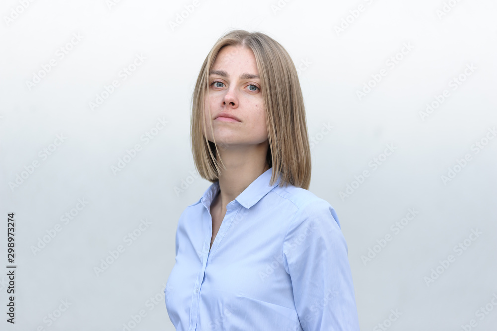 Blonde bussiness woman dressed casual with a perfect smile, standing near a white wall Blonde bussiness woman dressed casual with a perfect smile, standing near a white wall