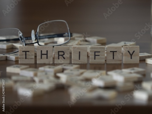 The concept of Thrifty represented by wooden letter tiles photo