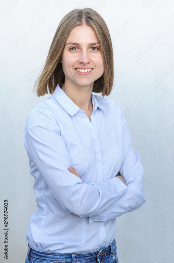 Portrait of a young successful woman working IT company on the background of the white wall Portrait of a young successful woman working IT company on the background of the white wall