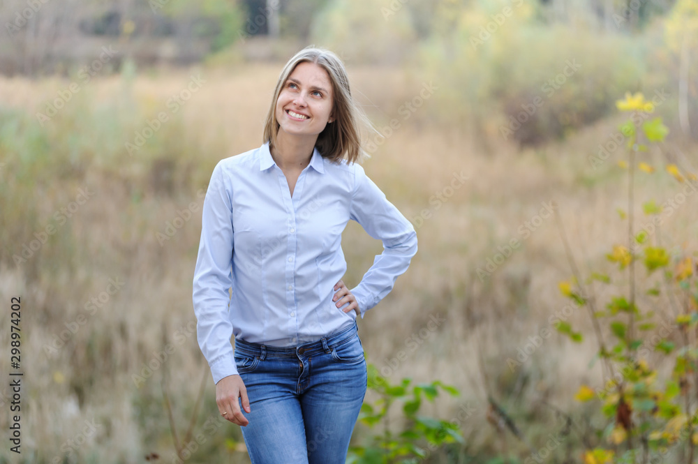 Casually dressed smiling business woman on a nature background Casually dressed smiling business woman on a nature background