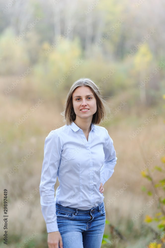 Casually dressed smiling business woman on a nature background Casually dressed smiling business woman on a nature background