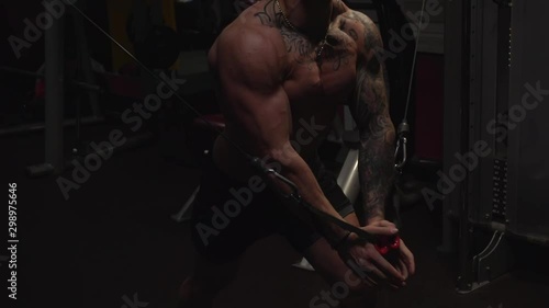 Fit guy doing peck muscles in gym machine, slow motion, shallow depth of field