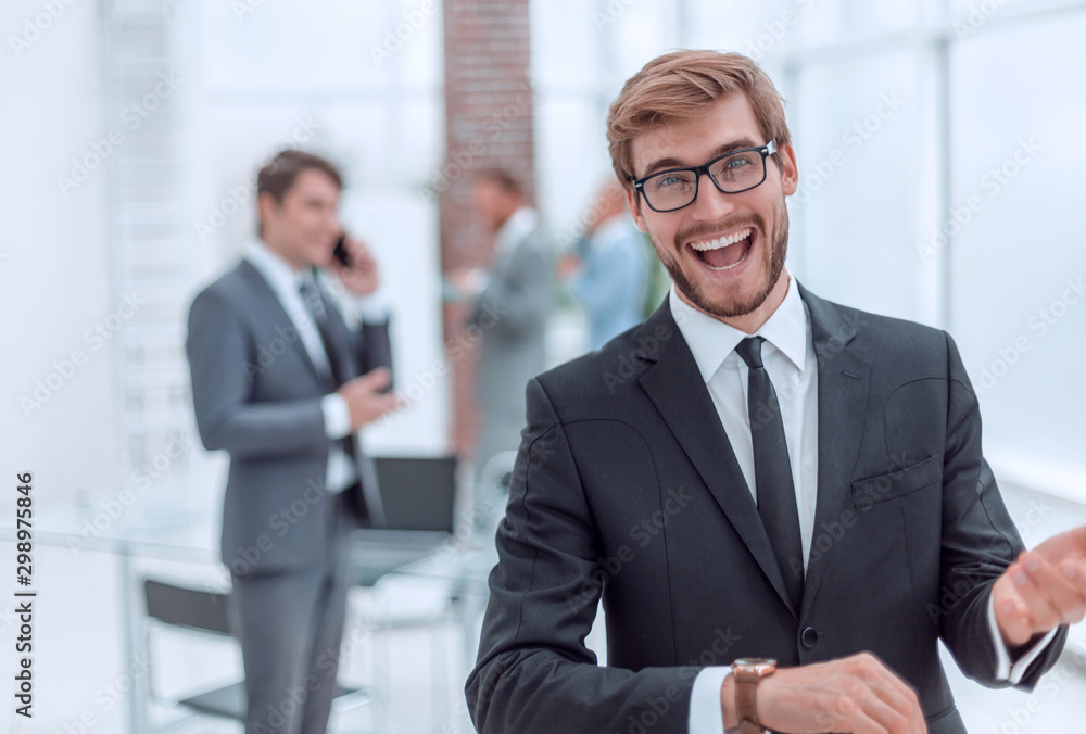 young businessman is waiting for someone standing in the office. young businessman is waiting for someone standing in the office.