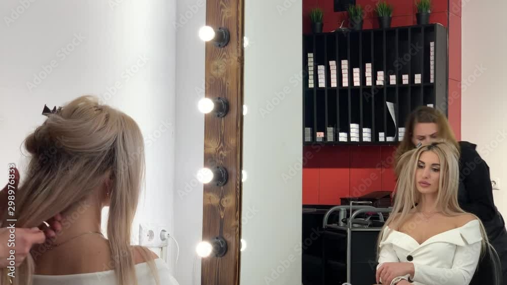 Hairdresser makes styling pretty blonde in a beauty salon. Hairdresser makes styling pretty blonde in a beauty salon.