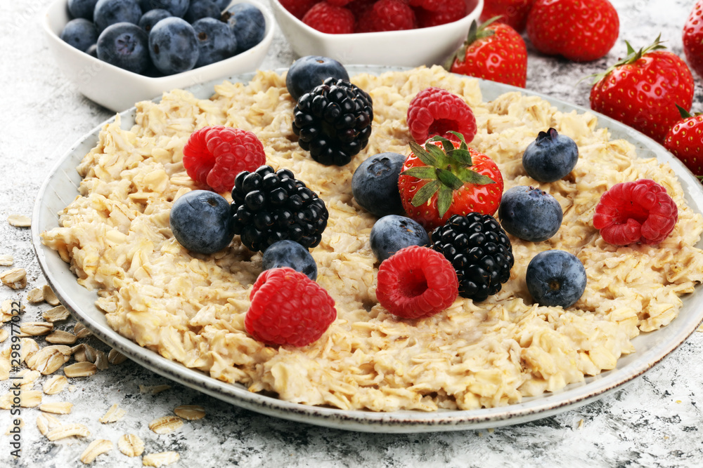 Bowl of oatmeal porridge with banana, raspberries coconut and caramel sauce on rustic table, hot and healthy food for Breakfast Bowl of oatmeal porridge with banana, raspberries coconut and caramel sauce on rustic table, hot and healthy food for Breakfast
