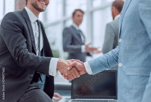 happy young businessman shaking hands with his business partner photo