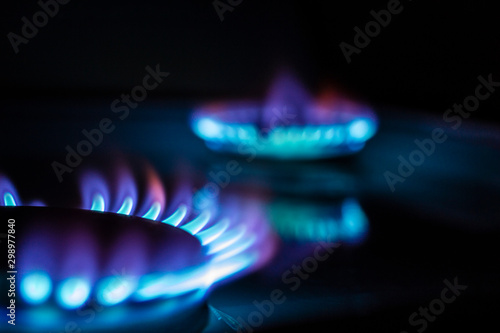 a hundred dollar bill on a gas burner with a burning fire on a black background, the front and back background is blurred with a bokeh effect photo