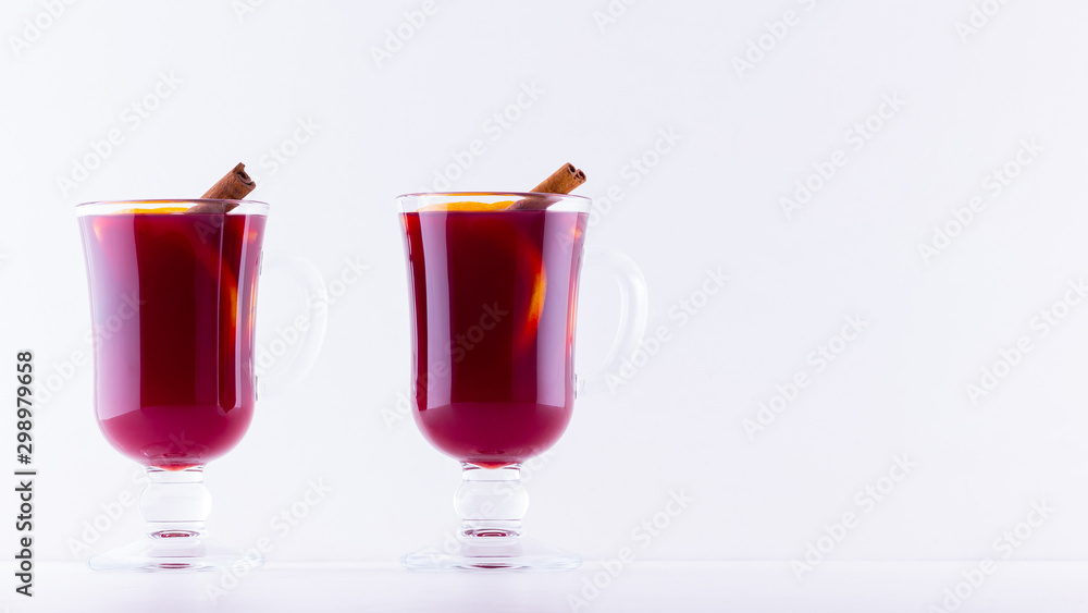 Glass of hot mulled wine with spices on white background. Christmas mulled wine with orange, star anise and cinnamon. Two glasses of winter Christmas drink Glass of hot mulled wine with spices on white background. Christmas mulled wine with orange, star anise and cinnamon. Two glasses of winter Christmas drink