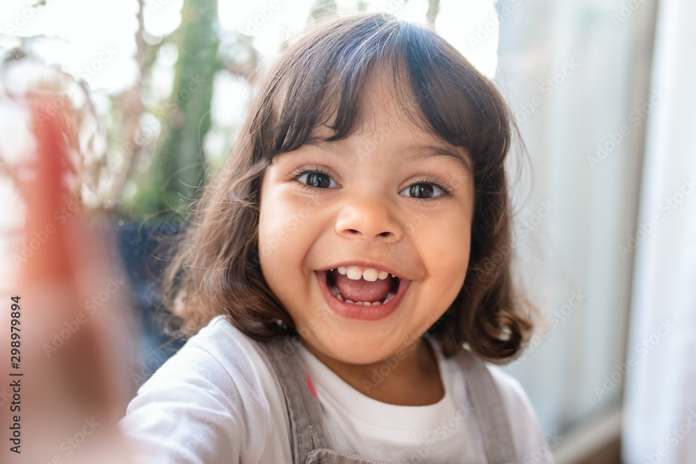 Smiling little girl taking a selfie while playing at home Smiling little girl taking a selfie while playing at home