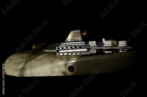 Bild auf Leinwand White electric guitar on black background.