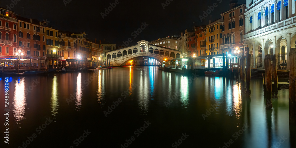 Panorama of the Grand Canal and famous Rialto Bridge or Ponte di Rialto in Venice at dark night, Italy.