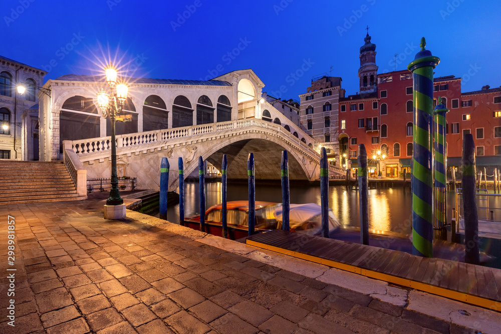 Famous Rialto Bridge or Ponte di Rialto over the Grand Canal in Venice during evening blue hour, Italy.