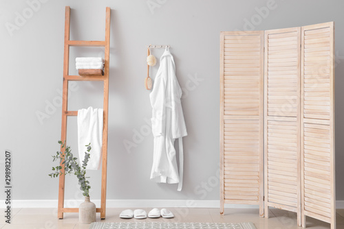 Clean bathrobe hanging on wall in room photo
