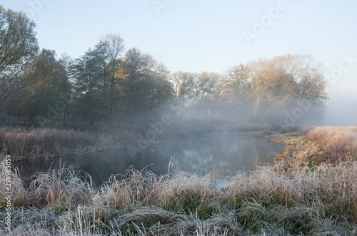 White frost on the grass, the first frost and fog over the lake. © Ruslan