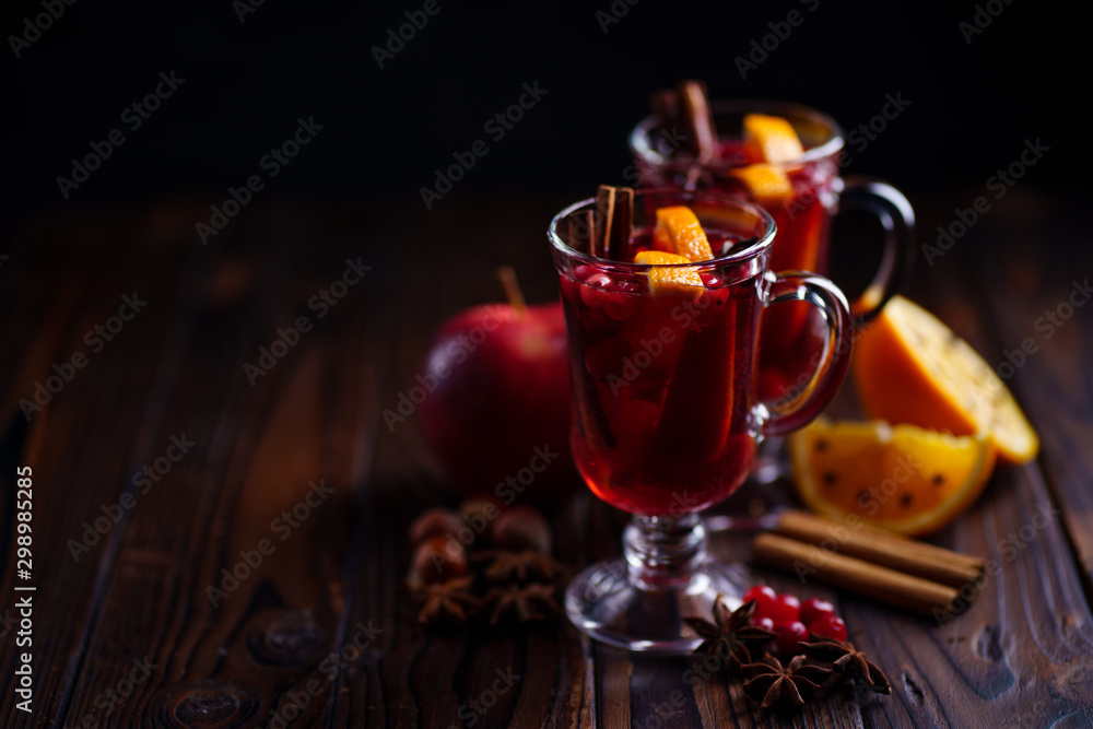 Mulled wine with aromatic spices and fruits on wooden rustic table, copy space. Traditional Christmas time hot drink Mulled wine with aromatic spices and fruits on wooden rustic table, copy space. Traditional Christmas time hot drink