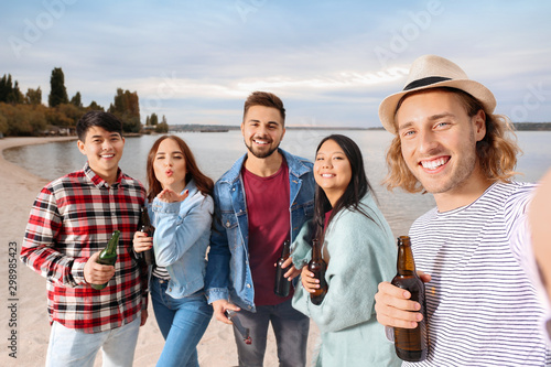 Friends taking selfie at barbecue party near river