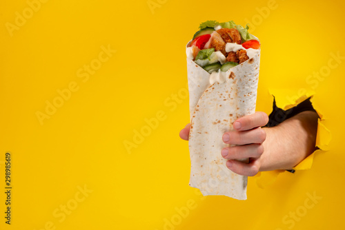 Hand giving a doner roll