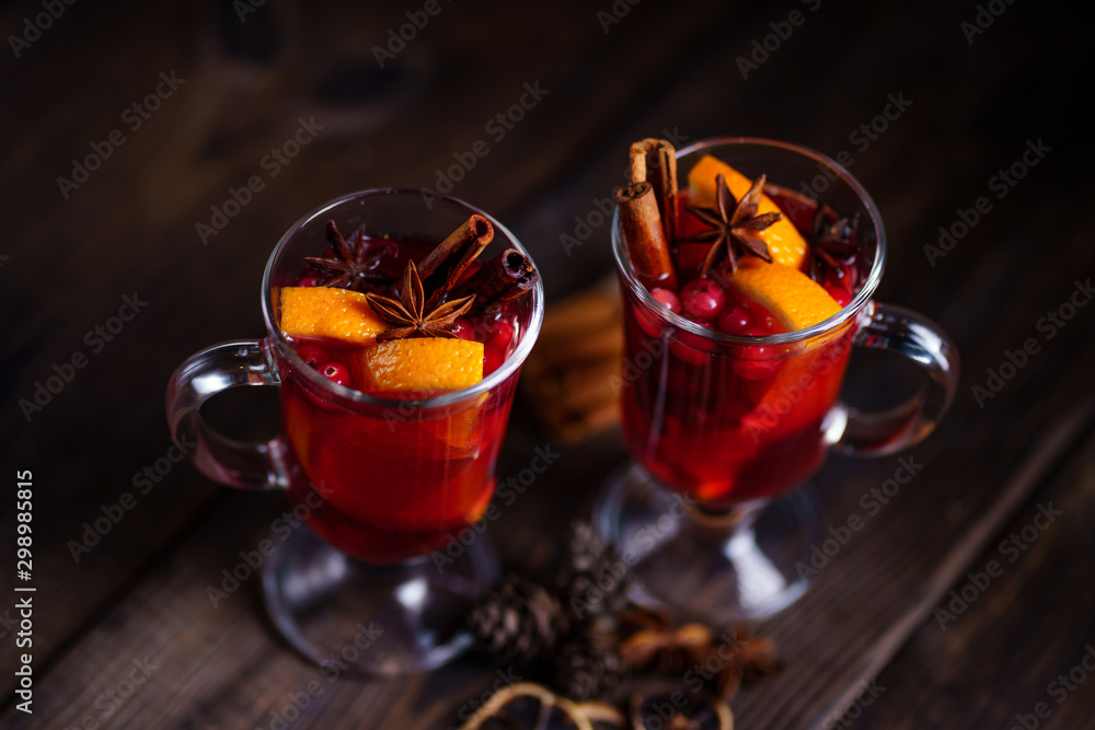 Mulled wine with aromatic spices and fruits on wooden rustic table, copy space. Traditional Christmas time hot drink Mulled wine with aromatic spices and fruits on wooden rustic table, copy space. Traditional Christmas time hot drink