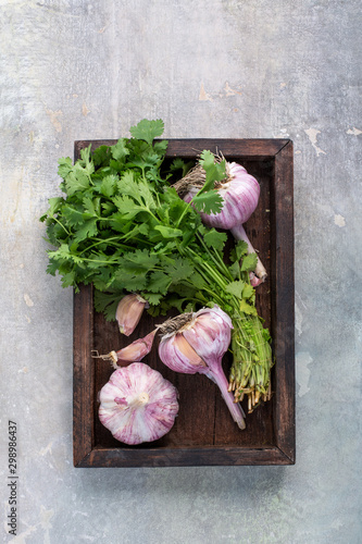  Garlic with herbs in a wooden box on a background of old plaster