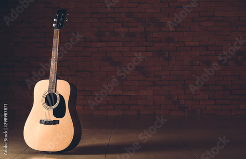 Fényképezés Modern acoustic guitar against dark wall