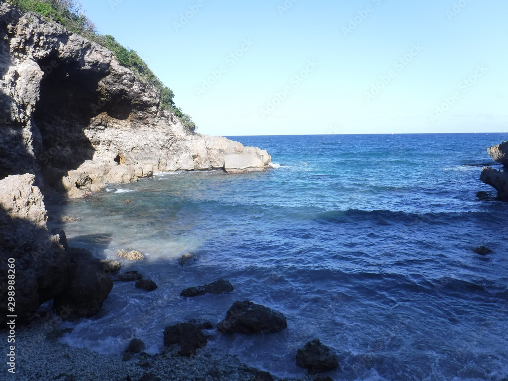 Une petite crique entourée d'une falaise formant une caverne