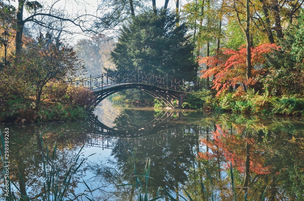 Beautiful autumn colorful landscape. Bridge in the city park in Pszczyna, Poland.