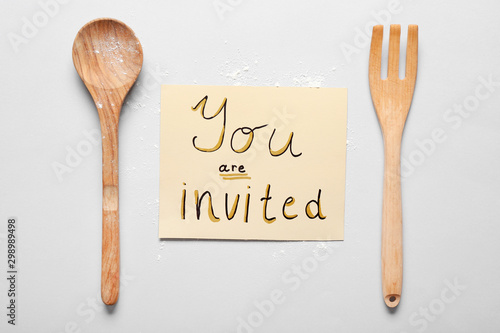 Invitation with kitchen utensils on white background
