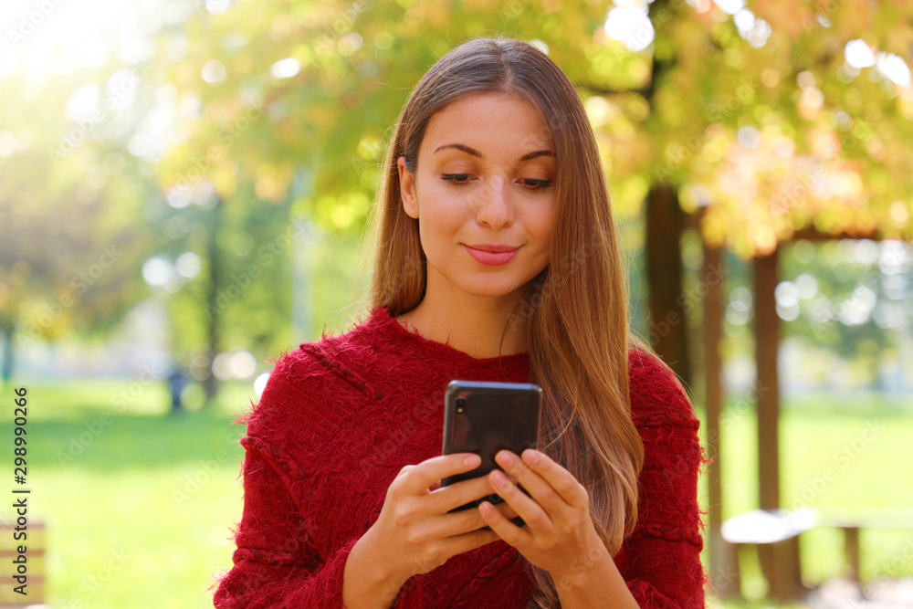 Close up of beautiful girl using internet browsing on smart phone on Autumn or Winter season. Close up of beautiful girl using internet browsing on smart phone on Autumn or Winter season.