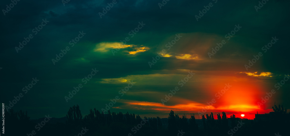 Fototapeta premium Landscape with dramatic light - beautiful golden sunset with saturated sky and clouds.