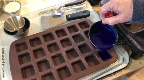 Pouring encaustic paint into silicone mold photo