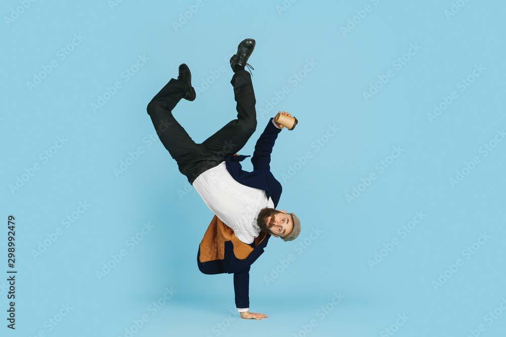 © master1305 - Young caucasian businessman having fun dancing break dance on blue studio background. Management, flexible, freedom, professional occupation, alternative way of modern working. Loves his job