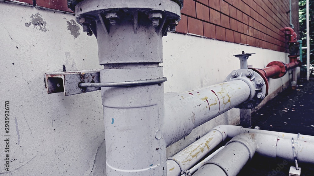 Connection point of pipes ventilation ducts For venting smoke outside the building, rusty surface surrounding with sunlight and wall background. Connection point of pipes ventilation ducts For venting smoke outside the building, rusty surface surrounding with sunlight and wall background.
