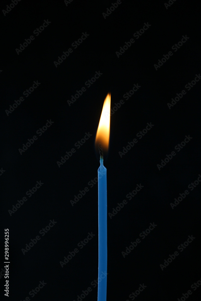 single candle with flame on a black background single candle with flame on a black background