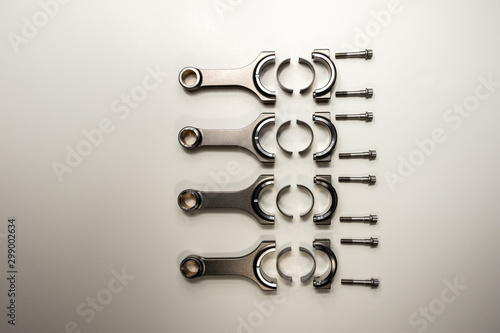 Foto four motorcycle conrods on a white background with big end shells and bolts
