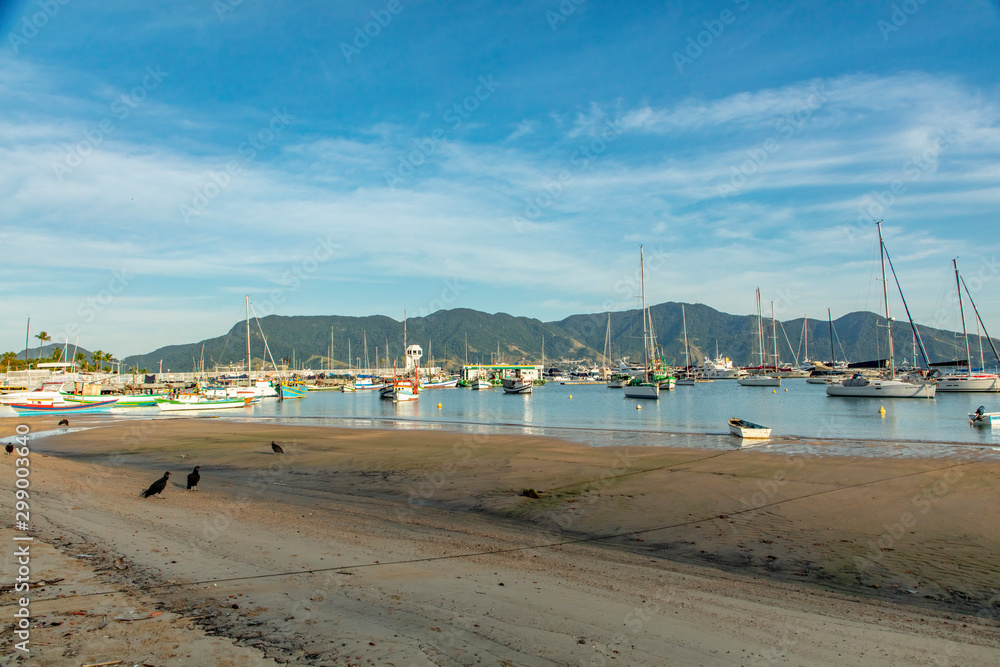 Boats in a bay on the coast of Sao Paulo on a beach in Ilhabela island with blue sea and clear sand in Brazil Boats in a bay on the coast of Sao Paulo on a beach in Ilhabela island with blue sea and clear sand in Brazil