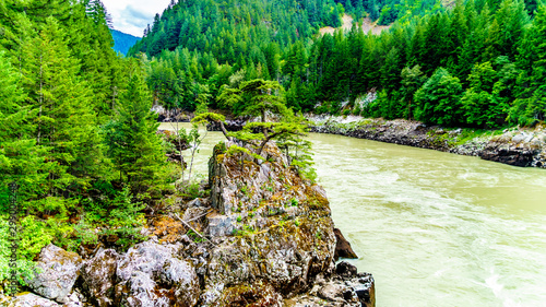 The rugged shoreline with large rock formations along the mighty Fraser River at the site of the Historic Second Alexandra Bridge  photo