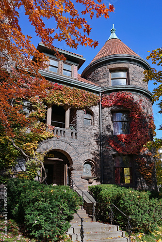 Foto Large old ivy covered stone building with fall colors