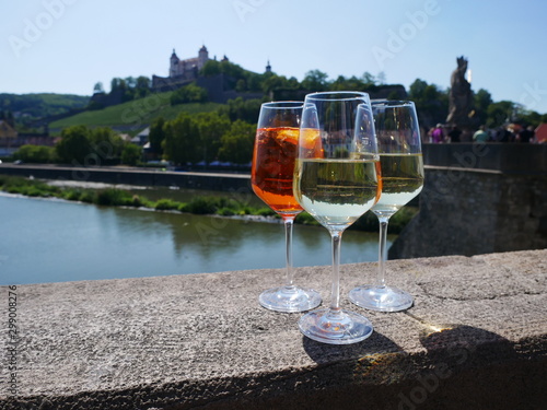 aperol und weißwein, gläser perspektive vor fluss und schloss photo