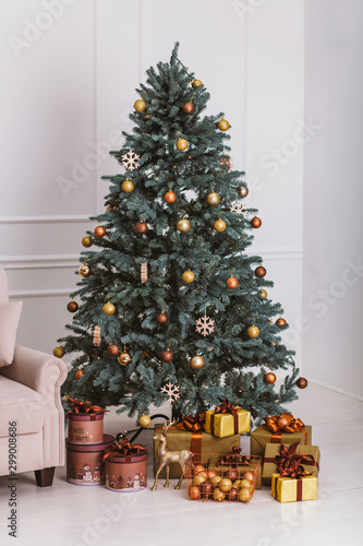 Christmas tree with decorations and gifts. Cozy Christmas atmosphere. The meeting of the new year at home. Stylish room interior with decorated Christmas tree.