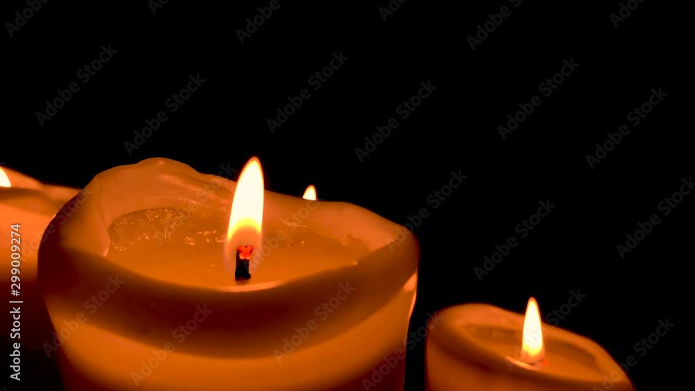 Orange lit candle on black background, small fire on wick: slow motion Orange lit candle on black background, small fire on wick: slow motion