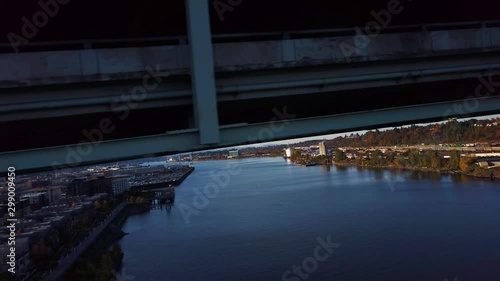 Climbing up the truss of tall freeway bridge to pan sideways at high speed following the cars on the deck. photo