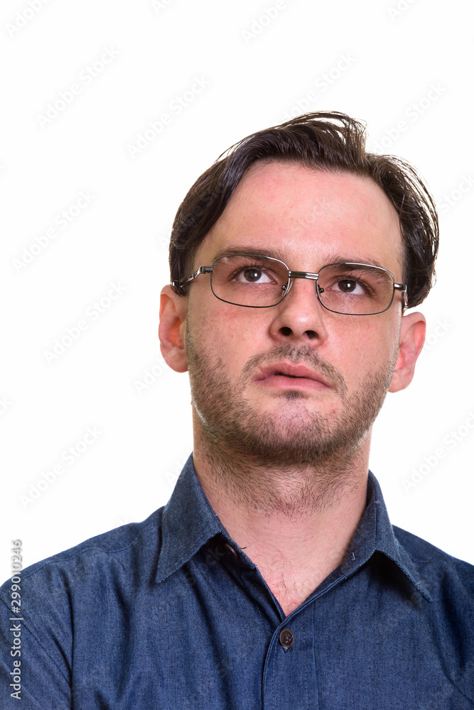 Face of formal young man thinking while wearing eyeglasses