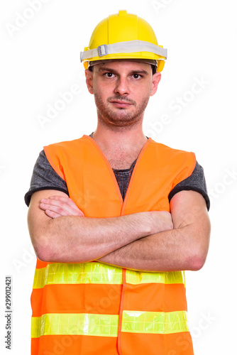 Studio shot of young man construction worker with arms crossed