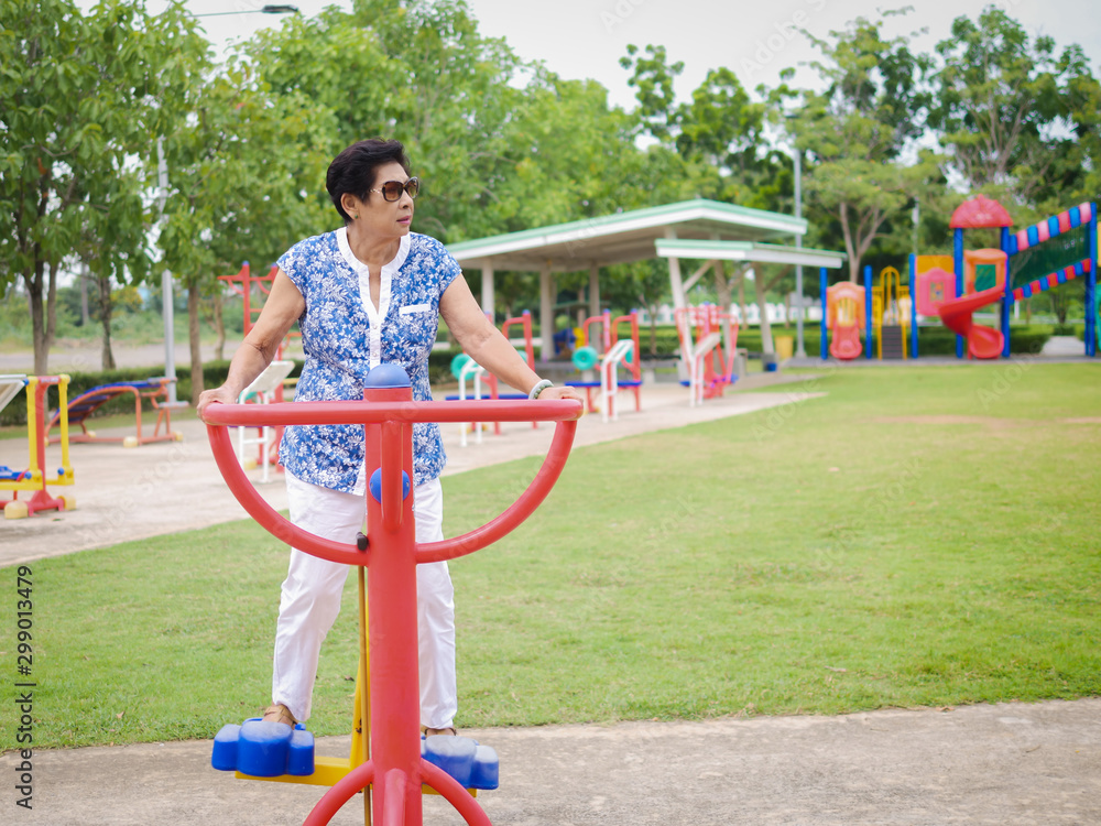 Asian senior woman doing exercise with outdoor equipment, lifetyle concept.