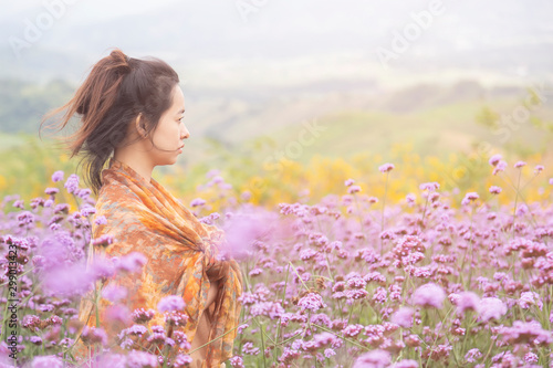 Romantic Asian women are standing to admire the beauty of flowers in the mountain gardens at Phetchabun province , Thailand.Travel with family cancept. photo