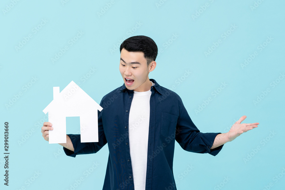 Asian man looking surprise holding house model for property concepts Asian man looking surprise holding house model for property concepts