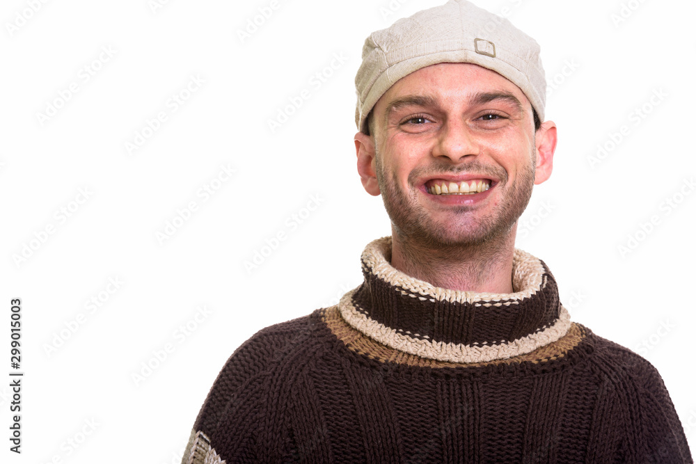 Studio shot of young happy man smiling while wearing hat Studio shot of young happy man smiling while wearing hat